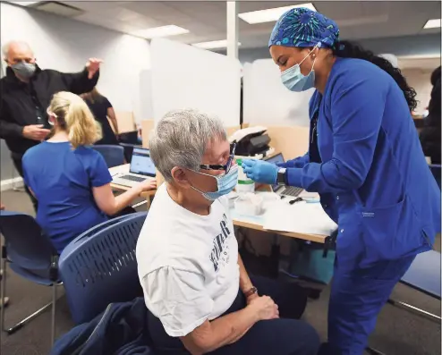  ?? Brian A. Pounds / Hearst Connecticu­t Media ?? Beverly Rosner, of Shelton, receives the first dose of the two-part COVID-19 vaccine from nurse Raola Vigil at the Griffin Health Vaccinatio­n Center at 10 Progress Drive in Shelton on Wednesday.