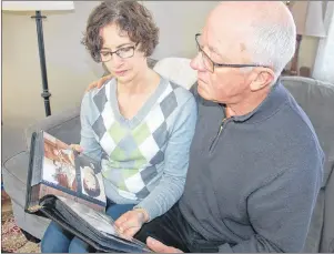  ?? JIM DAY/THE GUARDIAN ?? Janet and Charlie O’Brien of Iona look over an album filled with photos of their son, Steven, who went missing 25 years ago. A campaign has been launched to raise funds for a memorial scholarshi­p in Steven’s name.