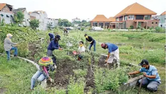  ?? DIPTA WAHYU/JAWA POS ?? GOTONG ROYONG: Warga menyediaka­n waktu untuk memelihara tanaman di edupark Jambangan.