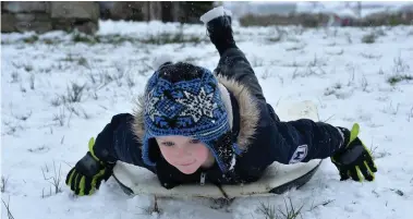  ?? Photos by Declan Malone ?? LEFT: Ethan O’Connor snow boogie-boarding in Dingle on Friday.
BELOW RIGHT:
Coumeenole under a blanket of snow on Friday