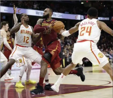  ?? TONY DEJAK — ASSOCIATED PRESS ?? LeBron James drives against the Hawks’ Taurean Prince (12) and Kent Bazemore in the second half Nov. 5