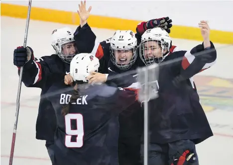  ?? RYAN REMIORZ/THE CANADIAN PRESS ?? U.S. players celebrate their 1-0 win over Canada in overtime in the gold medal game on Monday in Kamloops.