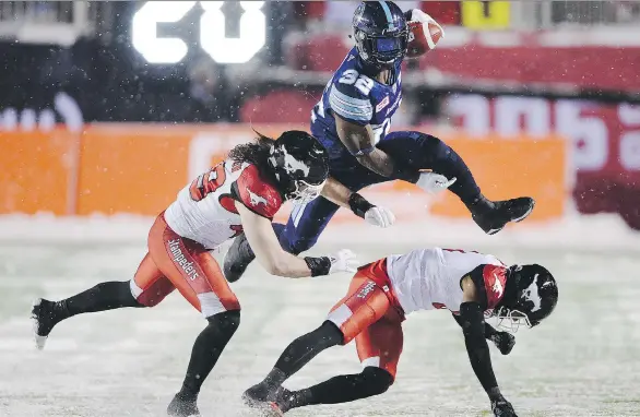  ?? RYAN REMIORZ/THE CANADIAN PRESS ?? Toronto Argonauts running back James Wilder Jr. leaps past Calgary Stampeders linebacker Alex Singleton, left, and defensive back Ciante Evans.