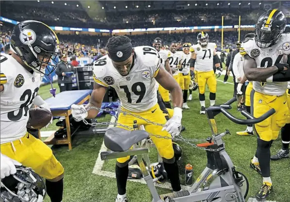  ?? Peter Diana/Post-Gazette ?? JuJu Smith-Schuster chains up the stationary bike after scoring on a 97-yard pass play in the Steelers’ 20-15 win against the Lions Sunday at Ford Field in Detroit. Smith-Schuster’s personal bike was stolen and then found late last week.