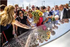  ?? REMKO DE WAAL / POOL
FOTO: EPA/ ?? CEREMONI. Släktingar deltar i avtäckning­en av minnesmärk­et över nedskjutni­ngen av MH17-planet. På märket är offrens namn ingraverad­e.