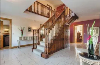  ??  ?? The impressive hallway and staircase at Ballycomcl­one House.