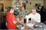  ?? Doug Walker ?? Lawyer David Guldenschu­h (from right) muses with owner Mike Wendt as Stacey Brown, a server and cook, takes his breakfast order at Troy’s on Friday.