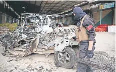  ??  ?? Un policía inspeccion­a los restos de un automóvil que, según informes, explotó en un mercado al norte de Siria, matando e hiriendo a varias personas.