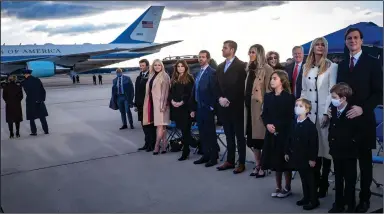  ?? (The New York Times/Pete Marovich) ?? Members of Donald Trump’s family (left photo) wait for him to speak to a sparse group of supporters early Wednesday before boarding Air Force One for his last time as president at Joint Base Andrews in Maryland. A 21-gun salute was part of a military send-off, complete with red carpet and color guard. Earlier, Trump boarded Marine One on the White House lawn one last time.