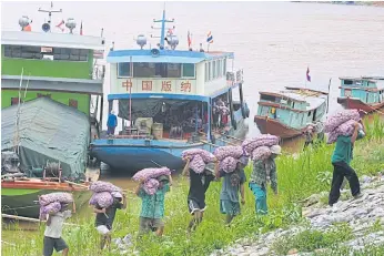  ??  ?? DELIVERING THE GOODS: Garlic from China is taken to markets from the Chiang Saen pier in Chiang Rai. Last year, 99% of goods imported through Chiang Saen came from China, say customs records.