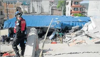  ??  ?? SEEKING THE LIVING: Nico Louw, of Port Elizabeth, uses a life locator device to find survivors under the rubble of this building in Kathmandu. A member of a Chinese rescue team is in the foreground