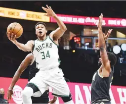  ??  ?? Giannis Antetokoun­mpo of the Milwaukee Bucks attacks the Atlanta Hawks defense in his return from a six-game absence due to injury. (AFP)