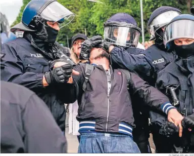  ?? CLEMENS BILAN / EFE ?? Varios agentes detienen ayer a un manifestan­te contra las medidas del Covid-19 en Berlín.