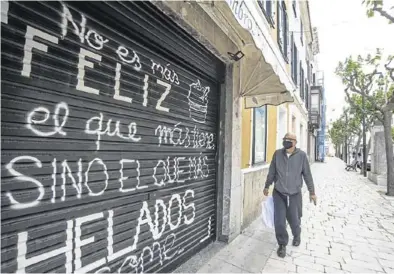  ?? EFE / DAVID ARQUIMBAU ?? Un hombre pasa ante un comercio cerrado debido a la actual crisis sanitaria, en Menorca.