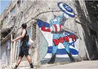  ?? (Jack Guez/AFP via Getty Images) ?? A MURAL drawn by the ‘Grafitiyul’ graffiti art group depicting US President Joe Biden dressed as the Marvel comics character “Captain America” standing before an Israeli flag and holding up his shield depicting the Star of David symbol, in Tel Aviv yesterday.