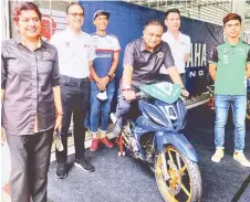  ?? — Bernama photo ?? Reezal Merican tries out a bike during his visit at the Sepang Internatio­nal Circuit (SIC) yesterday. Also seen are SIC chairman Tan Sri Mohamed Azman Yahya (second left), chief executive officer Azhan Shafriman Hanif (second right) and others.