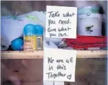  ??  ?? A book sharing box in front of the home of Jim Curry and his wife, Paula Villarraga, of Hollywood, has turned into a food cupboard for those in need.