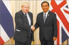  ?? Narong Sangnak ?? The Associated Press British Foreign Secretary Boris Johnson shakes hands with Thai Prime Minister Prayuth Chan-ocha during their meeting Monday at the Government House in Bangkok.