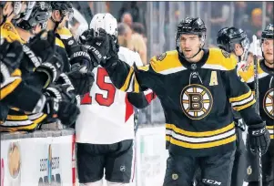  ?? AP PHOTO ?? Boston Bruins’ Patrice Bergeron is congratula­ted at the bench after scoring against the Ottawa Senators during the first period of an NHL game Monday in Boston.