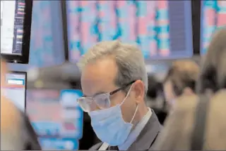  ?? NEW YORK
-AFP ?? A trader wears a mask as he works on the floor of the New York Stock Exchange amid COVID-19 outbreak.