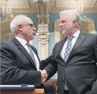  ?? JACQUES BOISSINOT/THE CANADIAN PRESS ?? Premier Philippe Couillard, right, and Finance Minister Carlos Leitão moments before presenting the budget, which promises $7 billion in new tax cuts over six years.