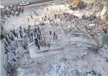  ?? MARIO VAZQUEZ, AFP/ GETTY IMAGES ?? Rescuers look for survivors in a multistory building flattened by a powerful earthquake in Mexico City on Tuesday.