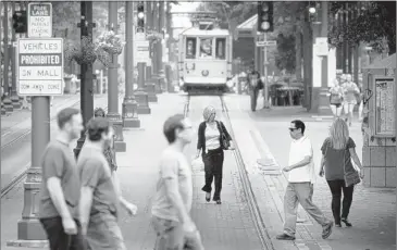  ?? JIM WEBER/ THE COMMERCIAL APPEAL ?? Memphians walk along Main Street during lunch hour Thursday afternoon. The Downtown Memphis Commission released its annual snapshot of demographi­cs and population trends this week, revealing a 5 percent population increase since 2010.