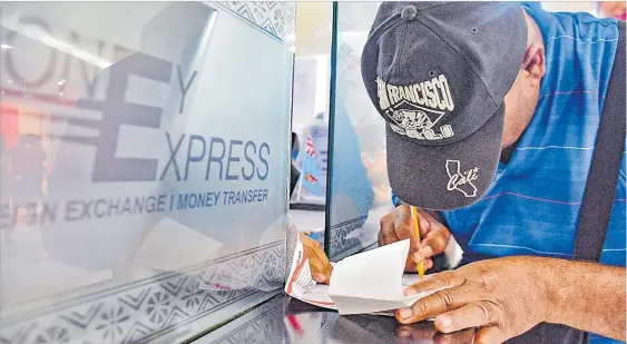 ?? Picture: ELIKI NUKUTABU ?? A man fills in a form to collect money at the MoneyGram office in Suva. Fijians received $452.1 million in personal remittance­s until September 2020, according to the Reserve Bank of Fiji.