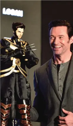  ??  ?? Australian actor Hugh Jackman looks at a gift of a Wolverine puppet during a press conference for the film Logan in Taipei.