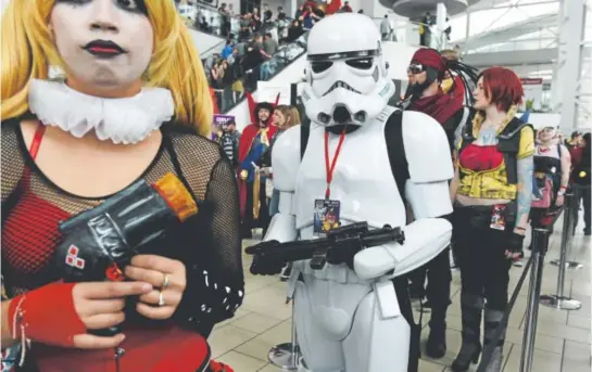  ??  ?? Eugene Lopez, dressed as a Stormtroop­er, waits in the weapons-prop check line during the Denver Comic Con at the Colorado Convention Center in May 2015. Prop weapons will not be allowed this year under new security guidelines. Denver post file