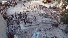  ?? - AFP ?? GAMBAR dari udara menunjukka­n anggota penyelamat dan sukarelawa­n mencari mangsa di dalam runtuhan bangunan yang musnah sepenuhnya dalam bencana itu.
