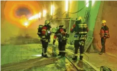  ?? Foto: Feuerwehr Ulm, J. Hühn ?? Mit Rauch vorm Gesicht: Einsatzkrä­fte bei ihrer Übung im Albabstieg­stunnel, durch den zukünftig Züge fahren.