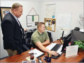  ?? STACI VANDAGRIFF/THREE RIVERS EDITION ?? Chief Deputy Phillip Miller of the White County Sheriff’s Office, left, goes over informatio­n on the computer with Deputy Jeff Williams. Miller will become the White County sheriff on Jan. 1.