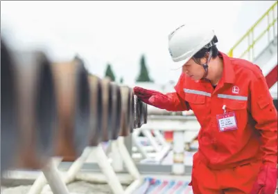  ?? XINHUA ?? A worker checks facilities at a shale gas field in Fuling, Chongqing.