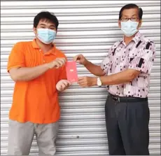  ??  ?? A custodian in Mukah, Penghulu Henry Lee Liong Ing (right) presents cash assistance to a recipient.