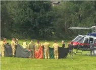  ?? AP ?? Rescue workers stand next to a police helicopter in Krimml in the Austrian province of Salzburg yesterday.