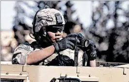  ?? HUSSEIN MALLA/AP ?? A U.S. soldier takes pictures Wednesday along a road leading to the front line with Turkishbac­ked fighters in Manbij, north Syria. The U.S. has about 2,000 troops in Syria.