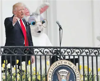  ??  ?? As the Easter bunny looks on, U.S. President Donald Trump speaks from the Truman Balcony during the annual White House Easter Egg Roll on the South Lawn of the White House on Monday.