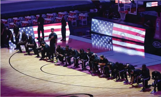  ?? FOTO: MARTA LAVANDIER/TT-AP ?? ■
Spelarna i Boston och Miami knäböjde inför NBA-matchen i protest mot orättvisor­na i USA.