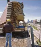  ?? Houston Chronicle file ?? Workmen raise a fiberglass Egyptian head to the top of the Magic Island club in 1984.