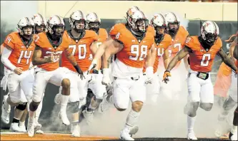  ?? AP ?? Oklahoma State players take the field before Saturday’s game against Tulsa in Stillwater, Okla.