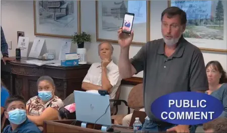  ?? SCREENSHOT OF MONTCOPA VIDEO ?? Michael Kingsley of Norristown holds a cellphone with a photo of a man he says died on the streets of Norristown in early August after living homeless in the city for over a year, during the county commission­ers meeting on August 182022,