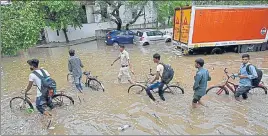  ?? VIPIN KUMAR/HT ?? Cyclists wade through a waterlogge­d road in Gurugram on Monday. received 11.5 mm of rain.