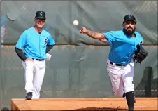  ?? DAVID SANTIAgO/MIAMI HERAlD VIA AP ?? Miami Marlins pitcher Sergio Romo (54) pitches as Marlins manager Don Mattingly (8) looks during the first full-squad spring training workout on Monday in Jupiter, Fla.