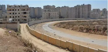  ?? (Udi Shaham) ?? THE ARAB village of Kafr Akab is seen beyond the security barrier. Jerusalem Affairs and Heritage Minister Ze’ev Elkin plans to separate this neighborho­od from Jerusalem.