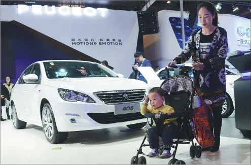  ?? ZHANG TAO / FOR CHINA DAILY ?? A young mother takes her child to an auto show in Zhengzhou, Henan province, on Nov 4, 2016.