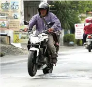  ?? DIMAS MAULANA/JAWA POS ?? RISIKO TINGGI: Dua pengendara sepeda motor terkejut saat melintas di atas tonjolan aspal di Jalan Kalirungku­t kemarin (30/12).