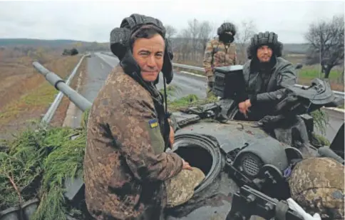  ?? // REUTERS ?? Un grupo de soldados ucranianos hace guardia en Bajmut en un tanque capturado a los rusos