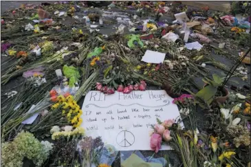  ?? The Associated Press ?? MEMORIAL: A notes and flowers form a memorial on Friday in Charlottes­ville, Va., at the site where Heather Heyer was killed. Heyer was struck by a car while protesting a white nationalis­t rally on Aug. 12.