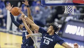  ?? John Peterson / Associated Press ?? Xavier’s Bryan Griffin, right, blocks a layup try by Creighton’s Marcus Zegarowski, center.